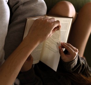 dos personas a las que ser ve pasar juntas la página de un libro